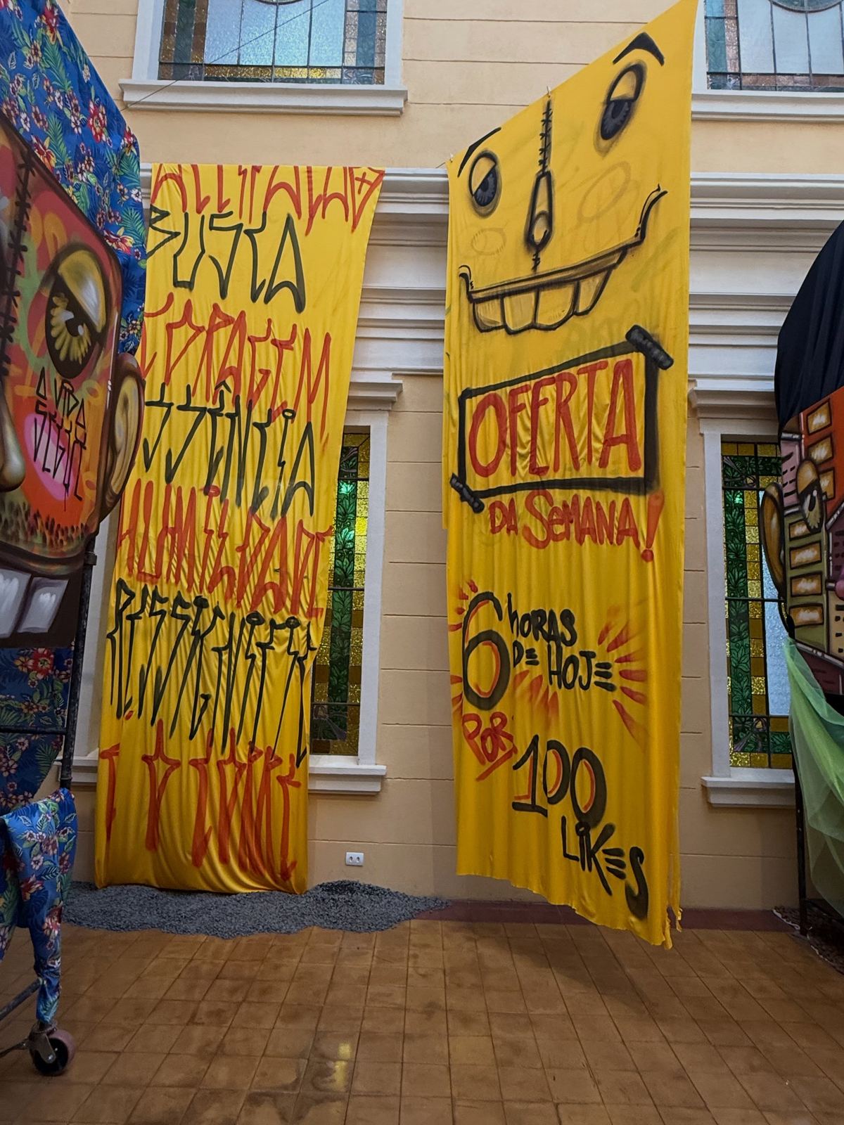 Tecidos amarelos pintados pendurados no pátio da Pinacoteca