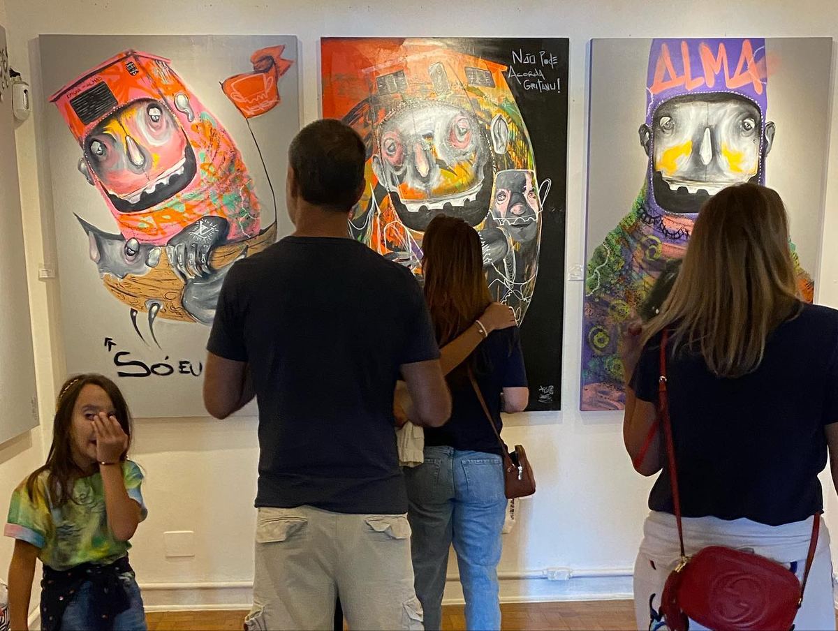 Visitantes diante das telas da exposição OCULTO