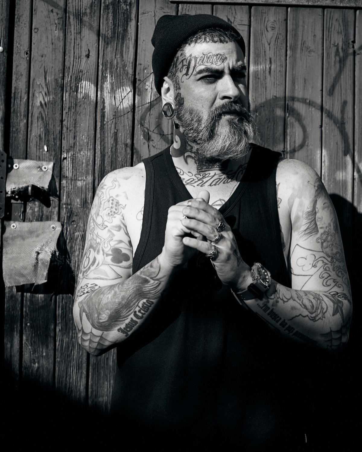 Retrato em preto e branco de Tico Canato, braços tatuados